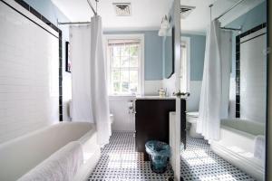 a bathroom with a tub and a sink and a tub and a bath tub at Beautiful fully-furnished Colonial in Millersville in Millersville +69 photos