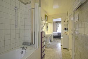 ein Bad mit einer Badewanne und einem Waschbecken sowie ein Zimmer in der Unterkunft Les Goélands maison avec vue sur port et falaise in Fécamp