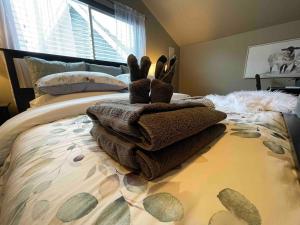 een bed met een stapel handdoeken erop bij Cozy loft in Upper Gibsons in Gibsons
