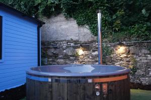 a large wooden tub in front of a stone wall at West Wicklow Glamping with Hot Tub in Baltinglass