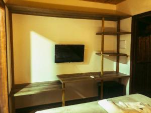 a bedroom with a desk and a tv on a wall at Vila Cris in Fernando de Noronha