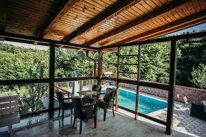 eine Terrasse mit einem Tisch und Stühlen sowie einem Pool in der Unterkunft Vila Odmor 