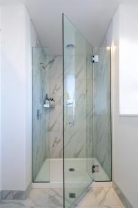 La salle de bains est pourvue d'une douche avec une porte en verre. dans l'établissement Harmony Hideout 2 bed 2 bath, à Christchurch