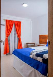 a bedroom with a blue bed and a window at Secretos del Eden in Ruiosucio