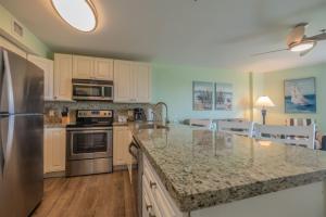 a kitchen with white cabinets and a granite counter top at 2405 Ocean Pointe in Tavernier