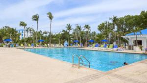 a pool at a resort with palm trees and blue umbrellas at 2306 Ocean Pointe in Tavernier