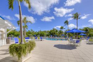 a pool at the resort with chairs and umbrellas at 1206 Ocean Pointe in Tavernier