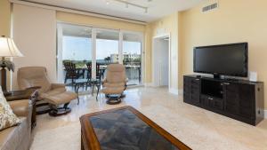 a living room with a flat screen tv and chairs at 122 Mariners Club in Key Largo