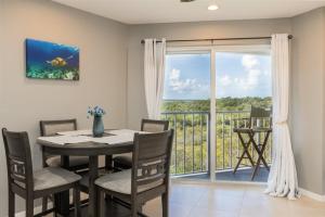 a dining room with a table and chairs and a balcony at 2402 Ocean Pointe in Tavernier