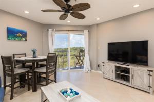 a living room with a dining table and a flat screen tv at 2402 Ocean Pointe in Tavernier