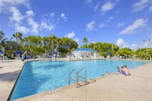 a swimming pool at a resort with people in it at 2402 Ocean Pointe in Tavernier