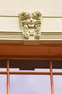 una estatua de una cara en la parte superior de un edificio en Ubytování U Vladaře, en Velhartice