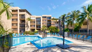 a swimming pool in front of a building with palm trees at B 405 Moon Bay in Key Largo