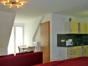 ein Schlafzimmer mit einem Bett und einem Tisch sowie eine Küche in der Unterkunft Ferienwohnungen mit Balkon in Kröslin