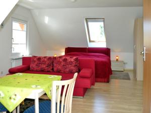 ein Wohnzimmer mit einem roten Sofa und einem Tisch in der Unterkunft Ferienwohnungen mit Balkon in Kröslin