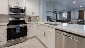 a kitchen with white cabinets and stainless steel appliances at 409 Mariners Club in Key Largo