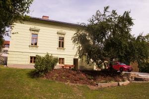 ein Haus mit einem roten Auto, das davor geparkt ist in der Unterkunft Ubytování U Vladaře in Velhartice