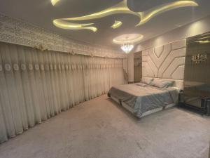 - une chambre avec un lit et un lustre dans l'établissement شقة للايجار في اسطنبول, à Basaksehir