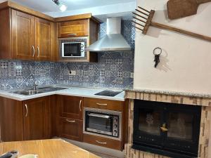 a kitchen with wooden cabinets and a stove top oven at Casa Angel in Cazorla