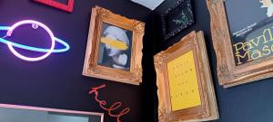 two framed pictures on a wall with neon signs at XOXO - Salinas in Ponferrada