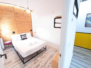 um pequeno quarto com uma cama e uma parede de madeira em XOXO - Salinas em Ponferrada