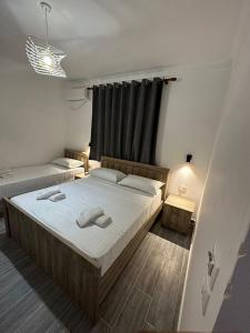 a bedroom with two beds and a black curtain at Rus Villa in Berat