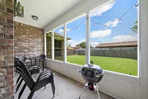 a grill on a porch with a view of a yard at City Getaway Yard Bbq Games Wifi Pets Ok in Houston