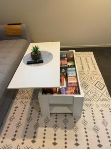 a white coffee table with a plant on top of a floor at Bunker on Belt in New Plymouth