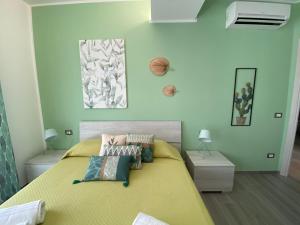 ein Schlafzimmer mit einem gelben Bett mit Kissen darauf in der Unterkunft La Terrazza del Capo in San Vito lo Capo