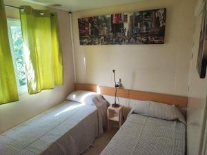 a small bedroom with two beds and a window at MOBIL GALA in Alhaurín de la Torre