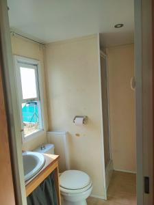 een badkamer met een toilet, een wastafel en een raam bij MOBIL GALA in Alhaurín de la Torre