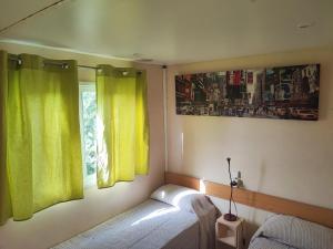 a bedroom with yellow curtains and a bed and a window at MOBIL GALA in Alhaurín de la Torre