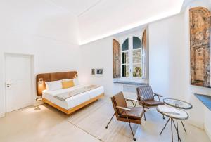 伊斯基亞的住宿－Faro Punta Imperatore，一间卧室配有一张床、两把椅子和一张桌子