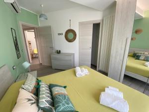 ein Wohnzimmer mit einem gelben Sofa und einem Bett in der Unterkunft La Terrazza del Capo in San Vito lo Capo