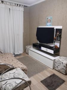 a living room with a tv on a stand at Praia Grande canto do forte in Praia Grande