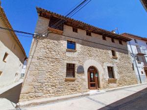 a stone building with a door on a street at La Fonda de Xiva in Chiva de Morella