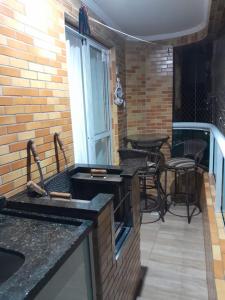 une cuisine avec un balcon équipé d'une table et de chaises dans l'établissement Praia Grande canto do forte, à Praia Grande