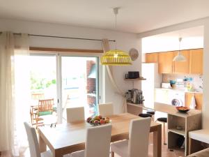 cocina y comedor con mesa de madera y sillas en Maré Cheia, en Tavira