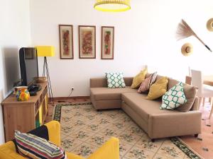 a living room with a couch and a tv at Maré Cheia in Tavira