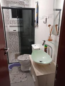 une salle de bain avec toilettes et lavabo vert dans l'établissement Praia Grande canto do forte, à Praia Grande 5 autres photos