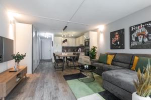 uma sala de estar com um sofá e uma mesa em Spirit Apartments - Suite #1 - Balkon - Bergsicht em Engelberg