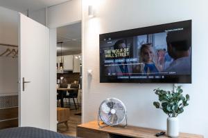 TV de pantalla plana colgada en la pared de la sala de estar. en Spirit Apartments - Suite #1 - Balkon - Bergsicht, en Engelberg