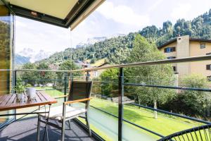 balcón con mesa y vistas a las montañas en Spirit Apartments - Suite #1 - Balkon - Bergsicht, en Engelberg