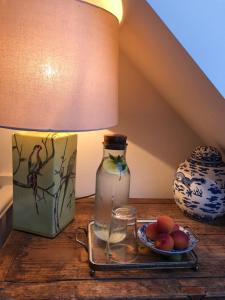 una mesa con una lámpara y un plato de fruta. en Halday, en Stafford