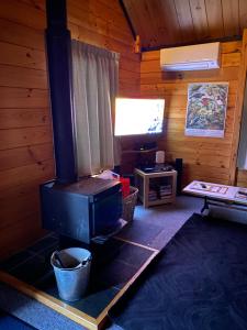 a living room with a stove in a cabin at Dakune Chill - The Chalet in Ohakune