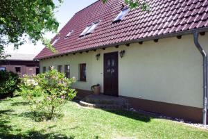 une petite maison blanche avec un toit rouge dans l'établissement Ferienwohnungen im Altbauernhaus, à Hohendorf