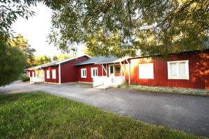 una fila de edificios rojos al lado de un estacionamiento en Skrå hostel - bed & business en Släda