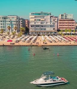 um barco na água em frente a uma praia em Gent's Inn em Durrës