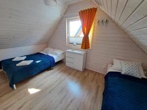 a bedroom with two beds and a window at Błękitne Zamorze in Niechorze