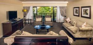 a living room with a couch and a tv at Southern Sun Bloemfontein in Bloemfontein
